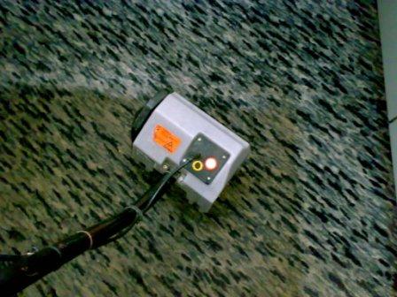 Profesjonalne urządzenie do czyszczenia dywanów na tle wzorzystej wykładziny w Poznaniu, widoczne włączone kontrolki.