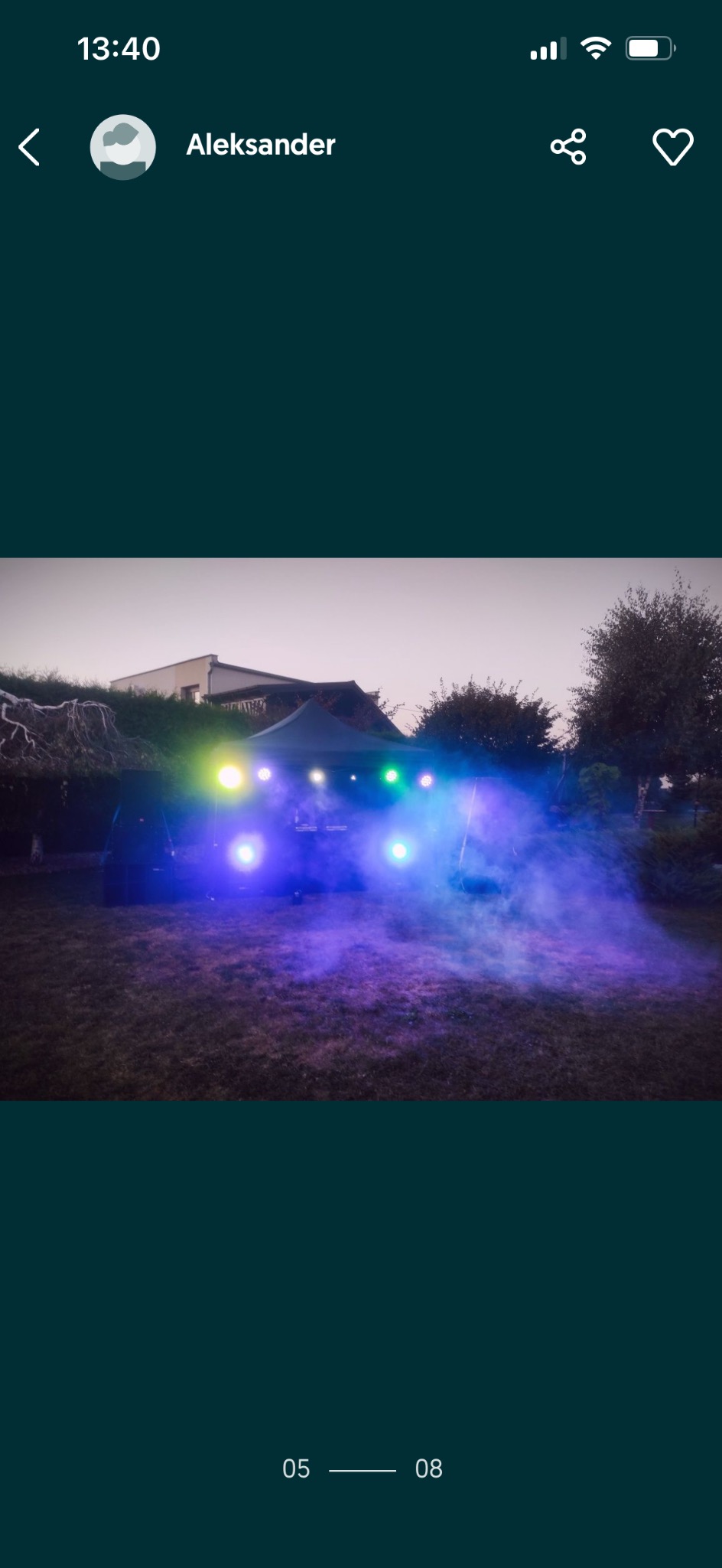 Oświetlony namiot eventowy z wytwornicą dymu na trawniku, wieczorową porą. Efektowne, kolorowe światła tworzą unikalną atmosferę.