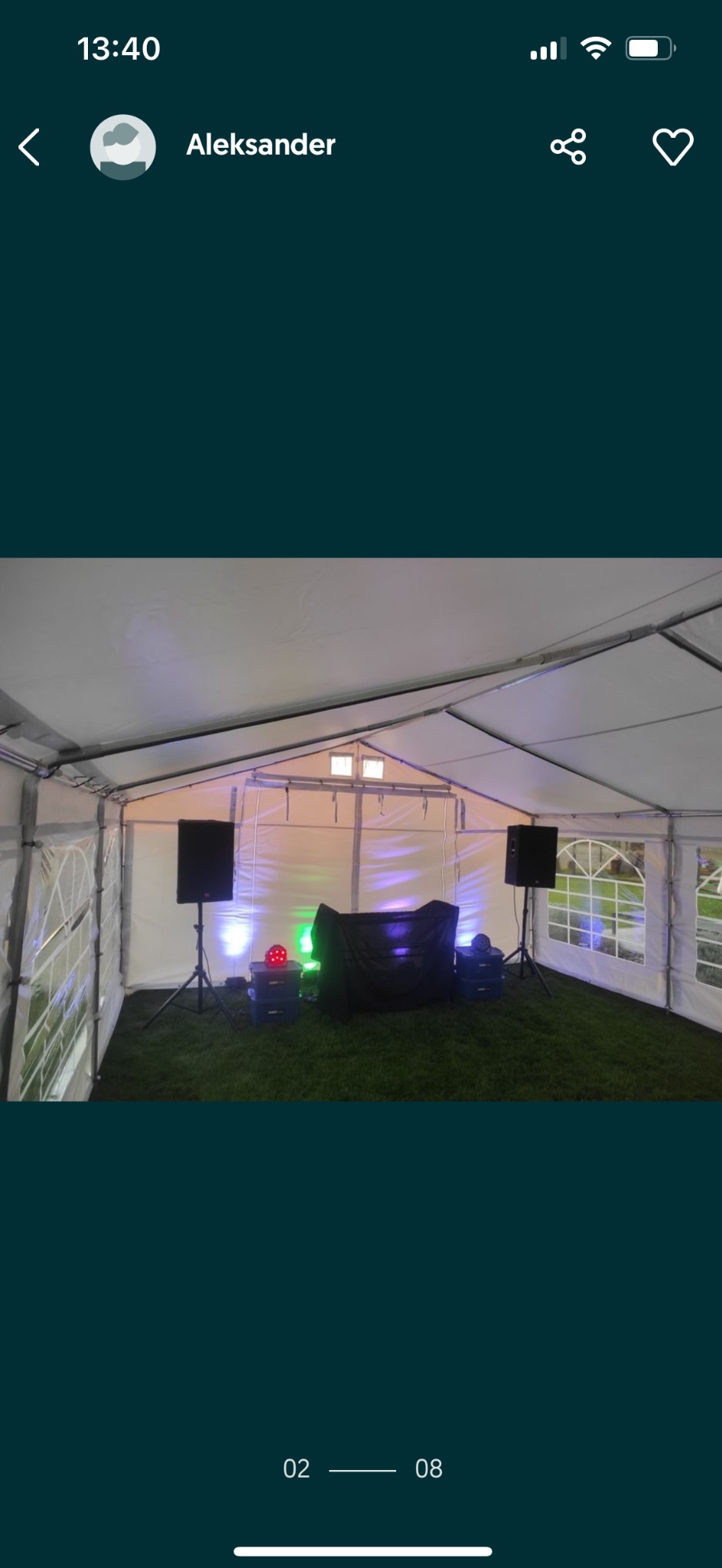 Wnętrze białego namiotu imprezowego z nagłośnieniem i oświetleniem, przygotowanego na trawie. Widoczne kolumny głośnikowe, oświetlenie dyskotekowe i stanowisko DJ-a.