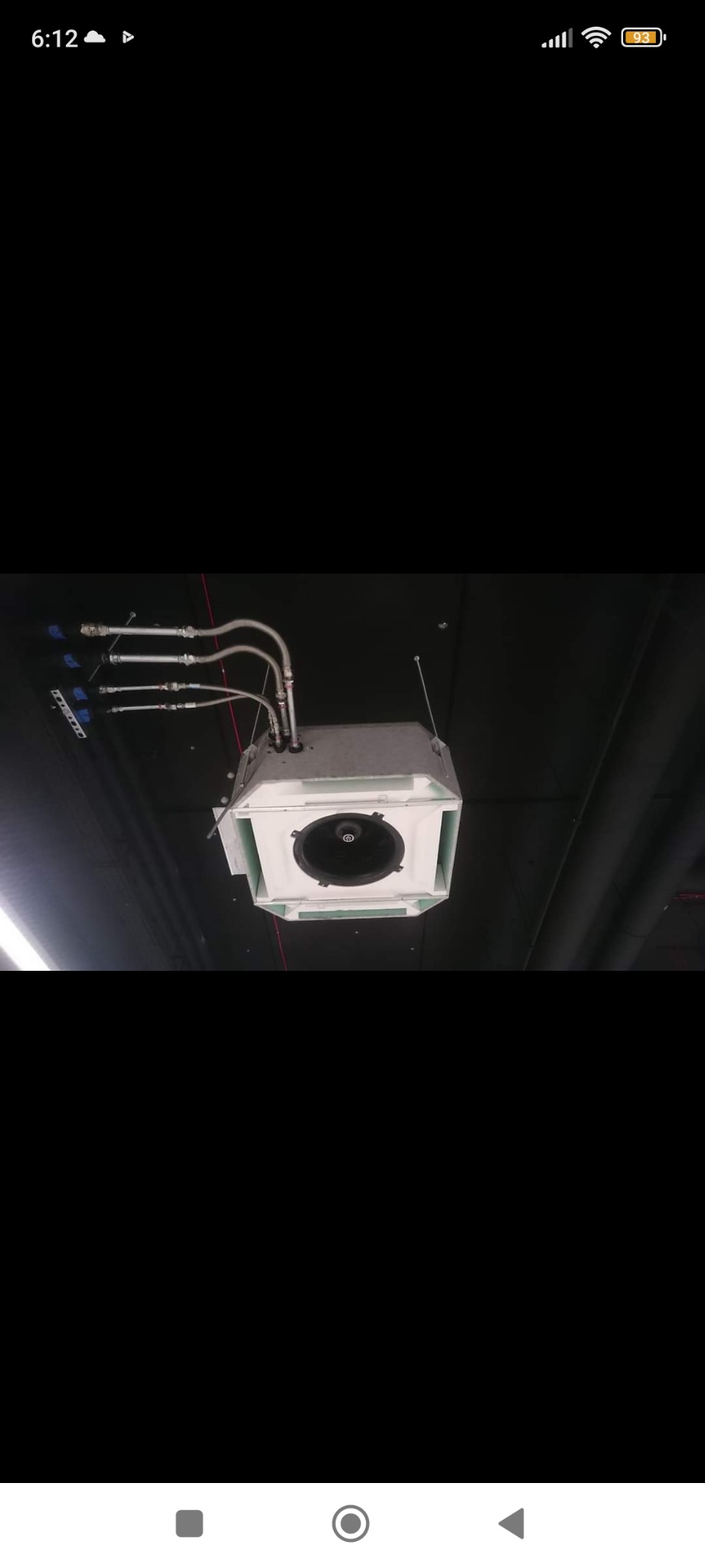 Widok od dołu na zamontowaną kasetę klimatyzacyjną w suficie, z widocznymi rurami doprowadzającymi czynnik chłodniczy.