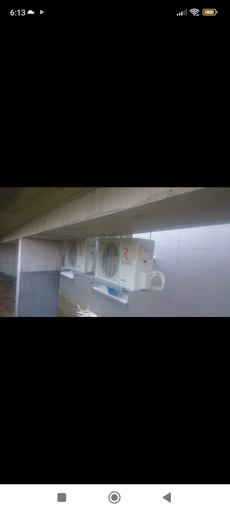 Dwa białe klimatyzatory Rotenso zamontowane pod betonowym stropem, widoczne przewody chłodnicze i instalacja elektryczna.