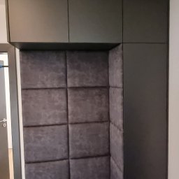 MEBLOTER Paweł Trytek - Tapicerowany narożnik wnękowy z szafkami górnymi w kolorze grafitowym. Miękkie panele ścienne w odcieniach szarości. Nowoczesny design, idealny do przedpokoju lub salonu.