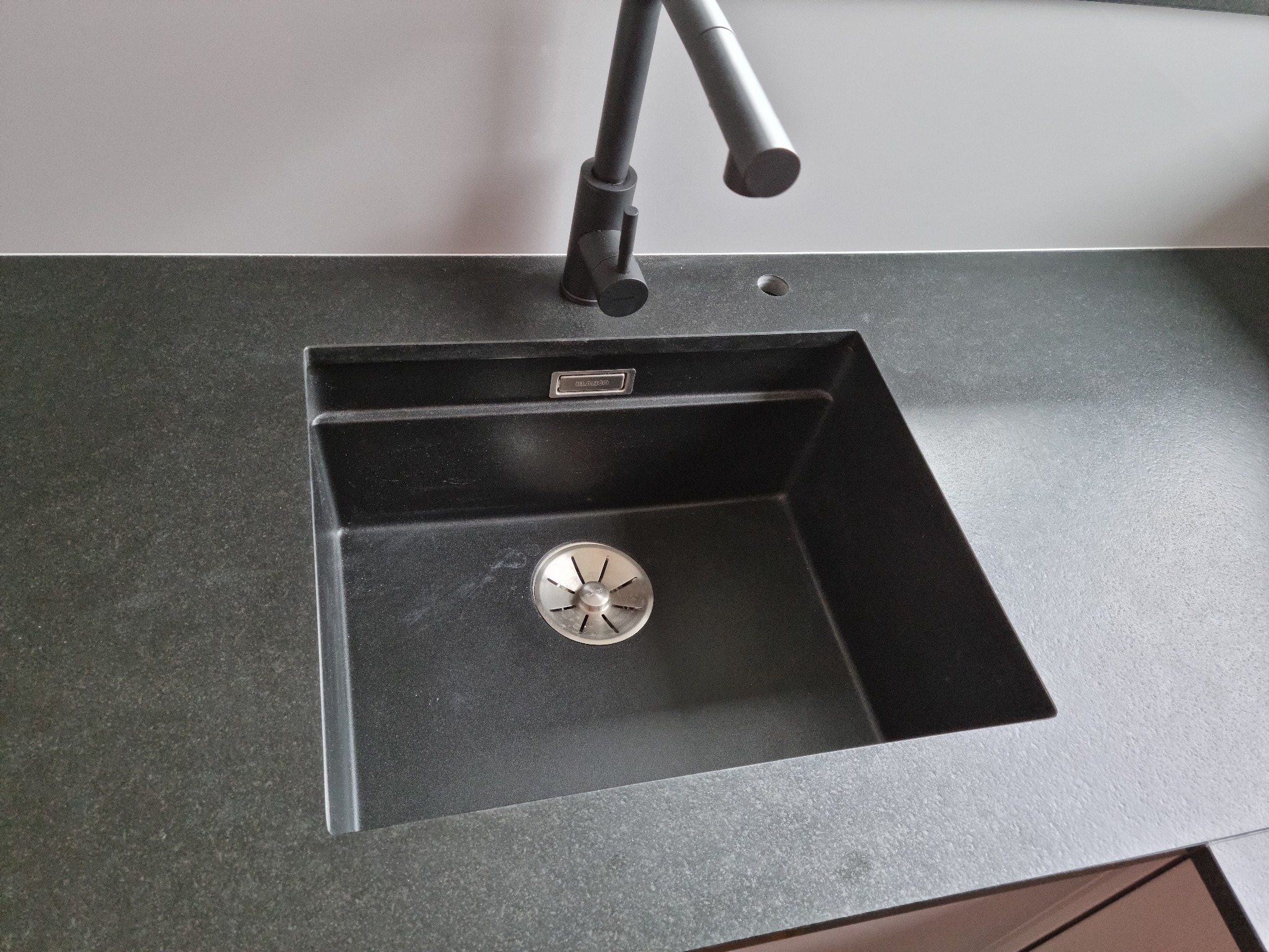 Czarny, granitowy zlew Blanco z baterią w kuchni, widok z góry. Minimalistyczny design, nowoczesne wykończenie blatu.