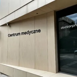 Elewacja budynku centrum medycznego z napisem 'Centrum medyczne' i logo 'doctorpro' na drzwiach wejściowych.