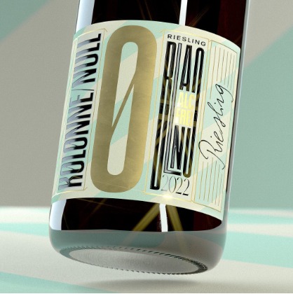 Butelka wina bezalkoholowego Kolonne Null Riesling 2022 z bliska, etykieta z geometrycznym wzorem i złotymi elementami.