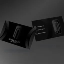 Dwie czarne wizytówki z logo i danymi kontaktowymi agencji reklamowej, lewitujące na szarym tle.