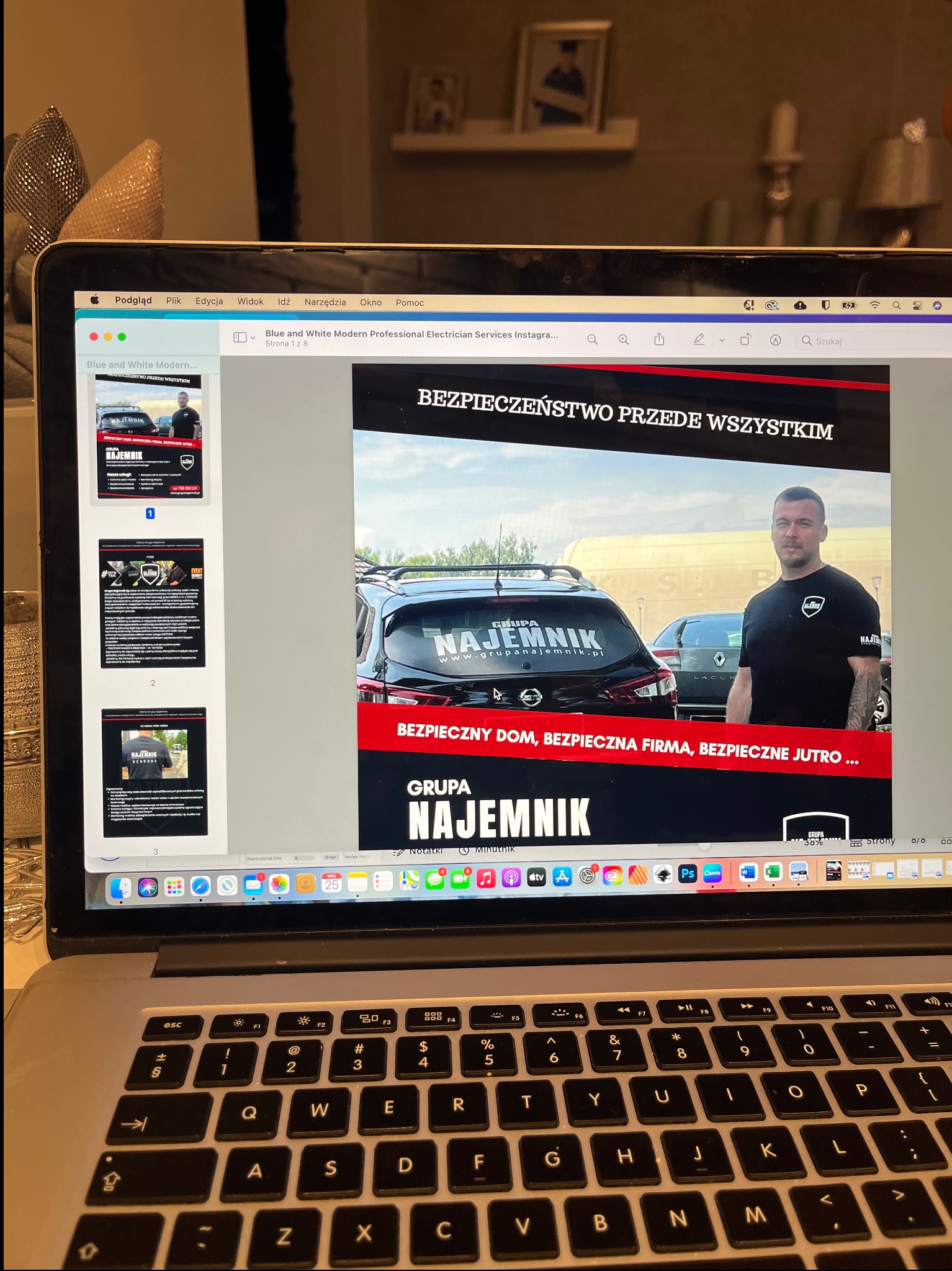 Ekran laptopa z otwartą prezentacją firmy ochroniarskiej 'Grupa Najemnik', z hasłem 'Bezpieczeństwo przede wszystkim' i zdjęciem pracownika na tle samochodów.