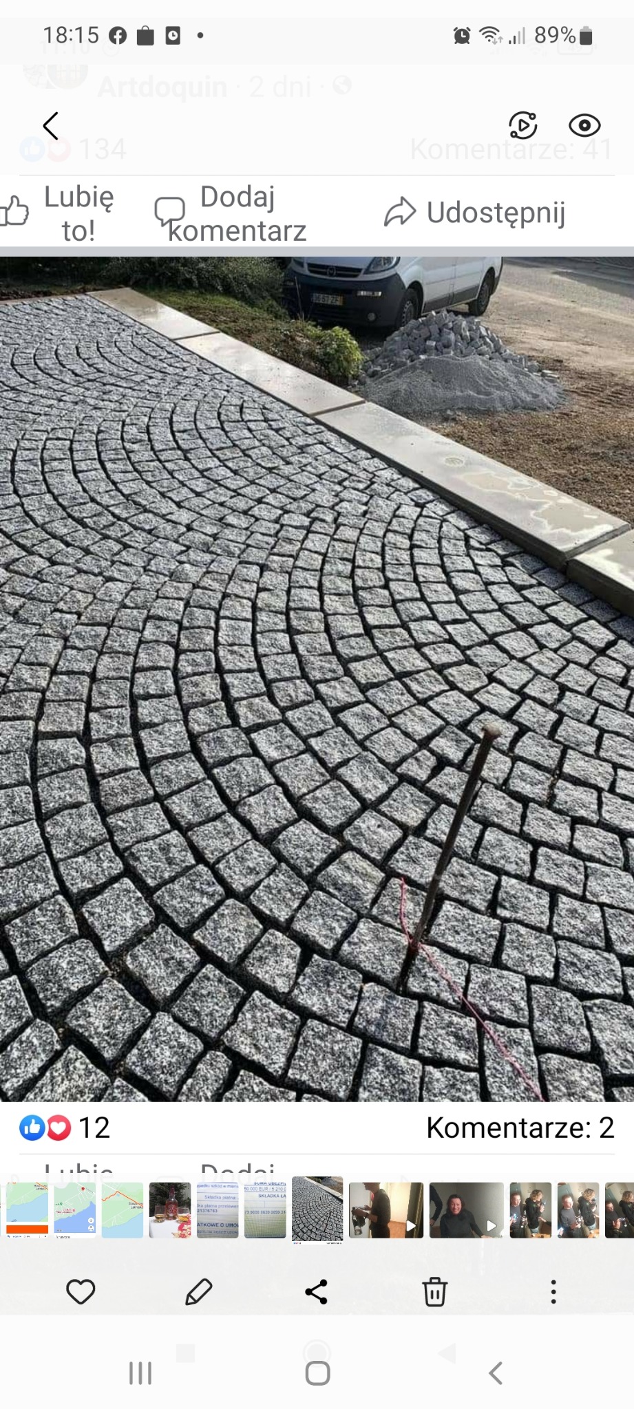 Układanie kostki granitowej w łukowaty wzór, widoczne narzędzie wbite w spoinę, w tle zaparkowany bus i pryzma kostki.