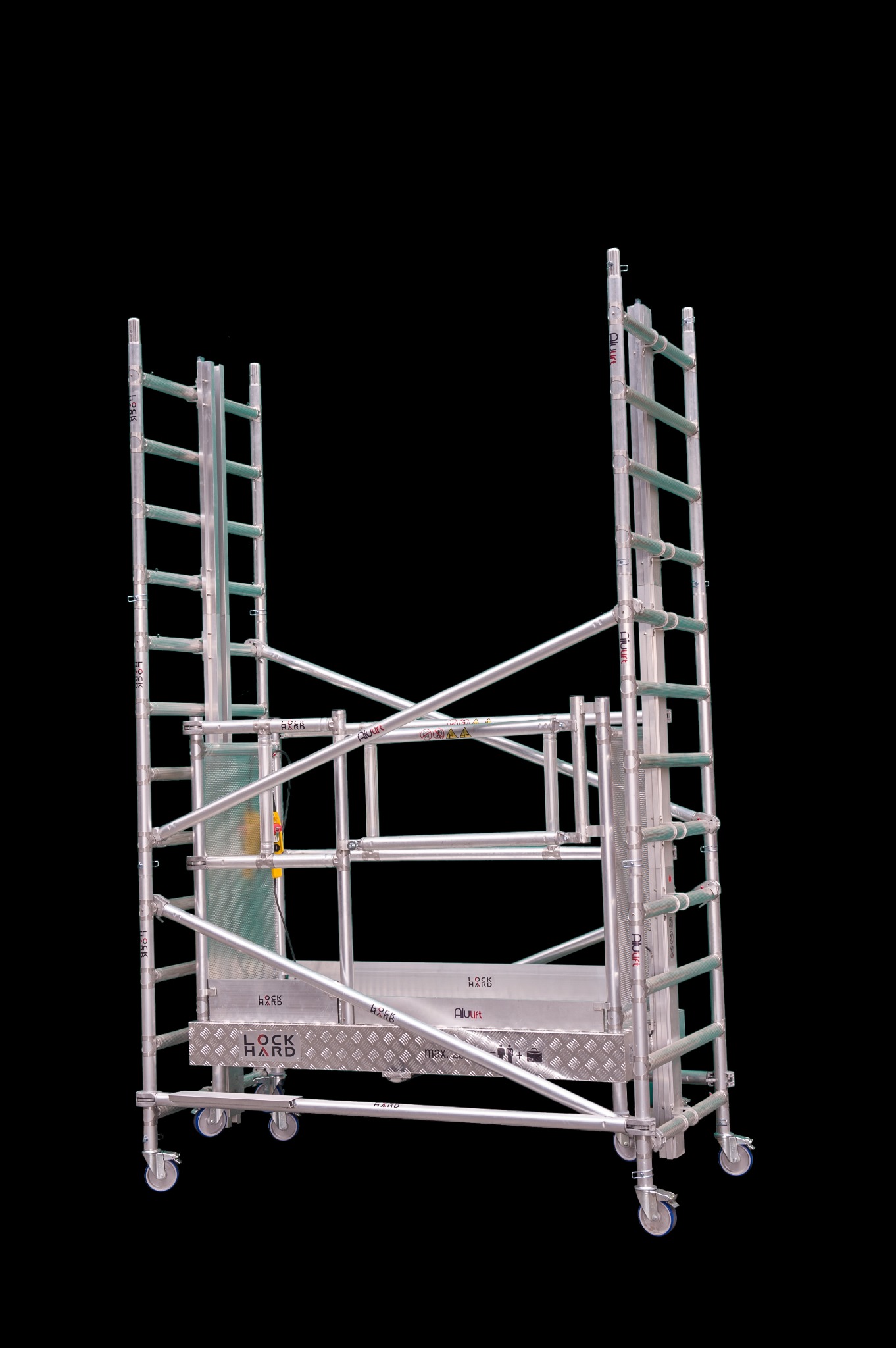 Rozłożony aluminiowy podest roboczy na kółkach z drabinkami, widoczne oznaczenia producenta Alulift i Lock Hard na czarnym tle.