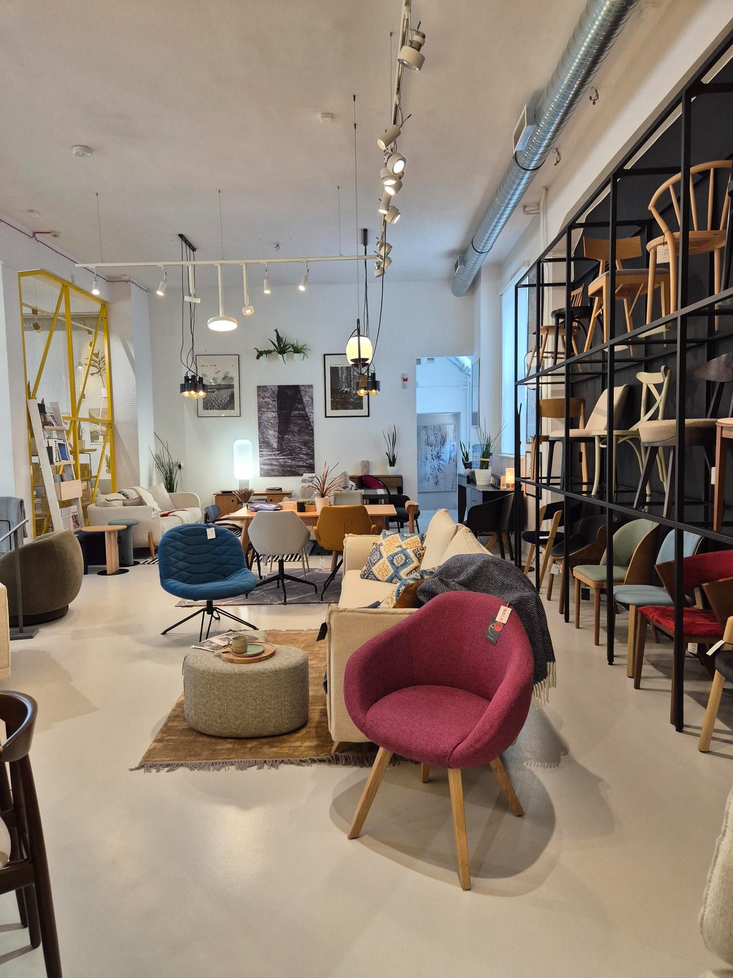 Salon meblowy z ekspozycją foteli tapicerowanych w różnych stylach, od nowoczesnych po klasyczne, na tle minimalistycznego wnętrza z oświetleniem punktowym.