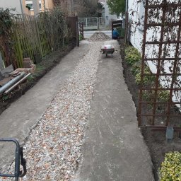 Piotr - Przygotowanie podłoża z gruzu pod ścieżkę w ogrodzie, widoczny wózek z zaprawą i narzędzia.