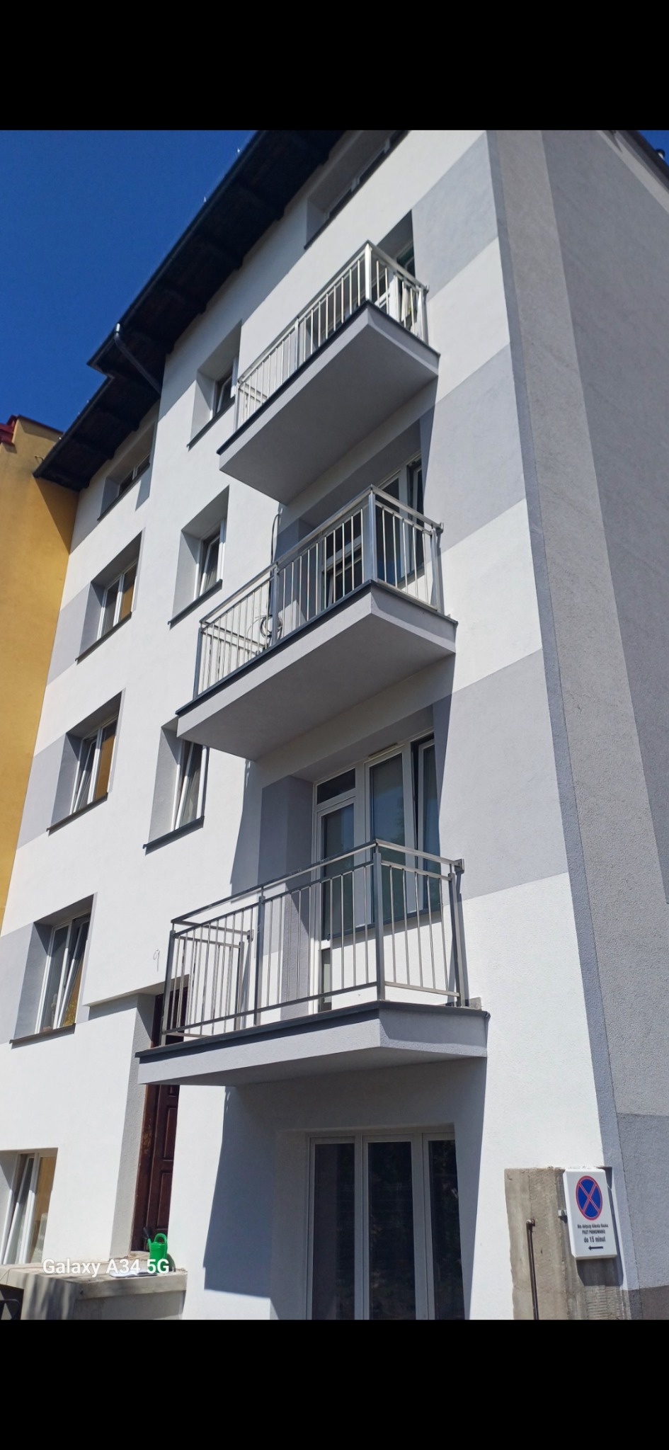 Nowoczesne balustrady balkonowe ze stali nierdzewnej w Łętowicach, zamontowane na odnowionym budynku wielorodzinnym z szaro-białą fasadą.