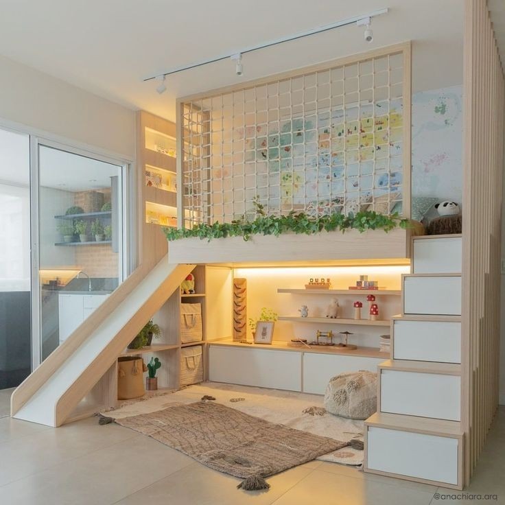 Pokój dziecięcy z antresolą do spania, zjeżdżalnią i schodami z wbudowanymi szufladami, oświetlony listwą LED, z siatką zabezpieczającą i mapą świata na ścianie, udekorowany roślinami i zabawkami.