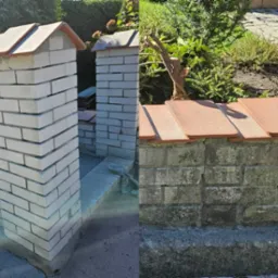 Nowo wymurowane, jasne, ceglane słupki ogrodowe z daszkami, kontrastujące ze starym, zabrudzonym ceglanym murem z terakotowymi płytkami na górze.