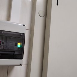 SYSTEMUS SP. Z O. O. - Panel sterowania chłodni z wyświetlaczem temperatury 11.2 stopni Celsjusza, zamontowany obok drzwi z napisem 'Chłodnia Nr. 1 Nabiał'.