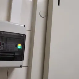 Panel sterowania chłodni z wyświetlaczem temperatury 11.2 stopni Celsjusza, zamontowany obok drzwi z napisem 'Chłodnia Nr. 1 Nabiał'.