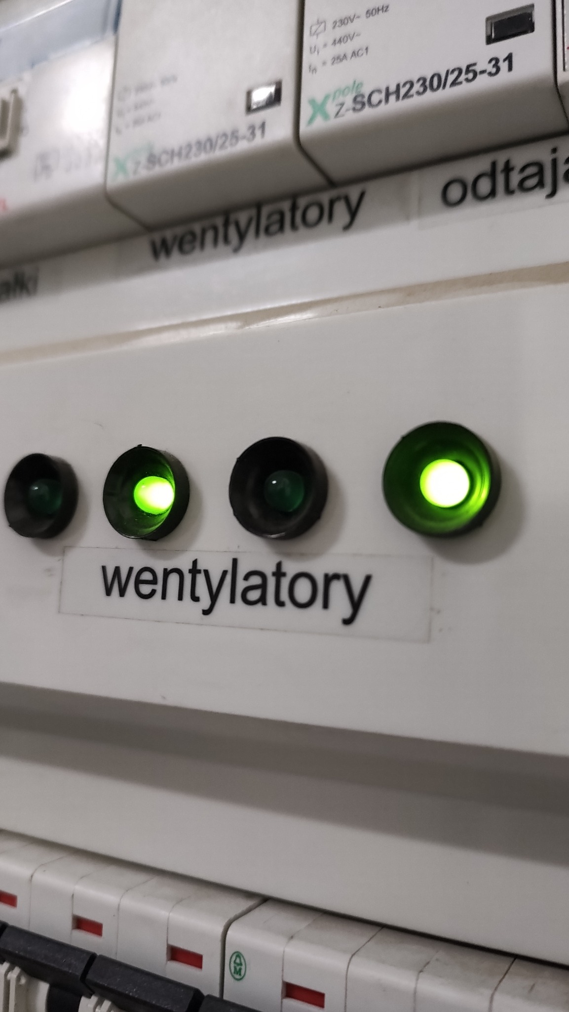 Panel sterowania z włącznikami i kontrolkami, opisany 'wentylatory', dwie zielone diody sygnalizacyjne świecące, pozostałe wyłączone, widoczne bezpieczniki.