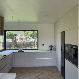 Kaszmirowe kuchnia za złotymi listwami i blatem kompaktowym