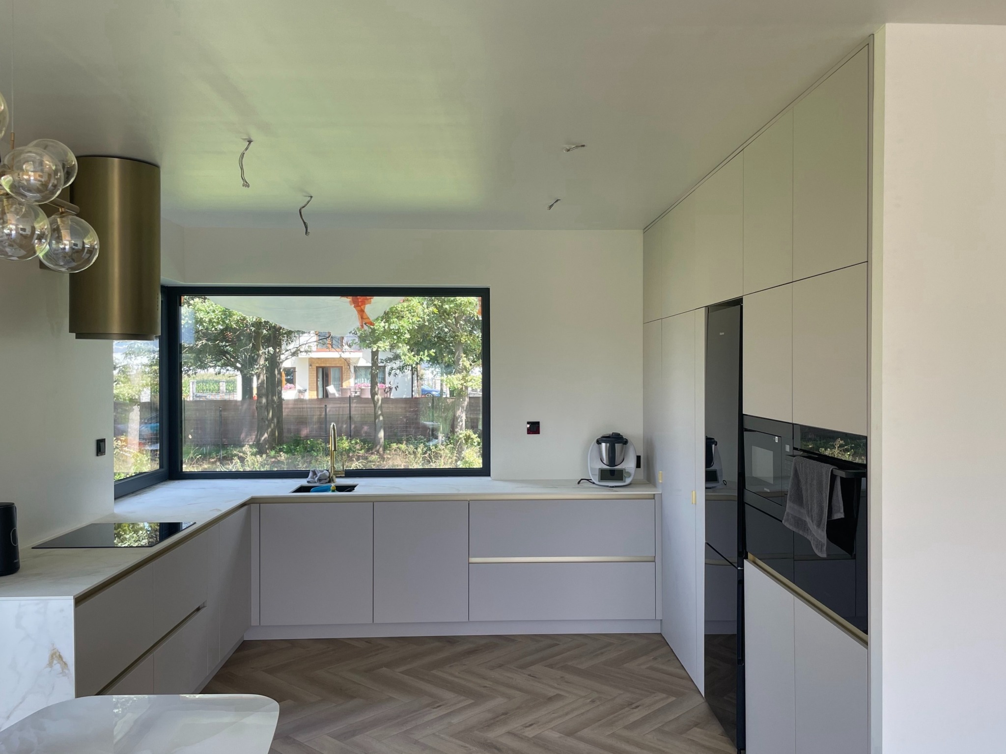 Kaszmirowe kuchnia za złotymi listwami i blatem kompaktowym