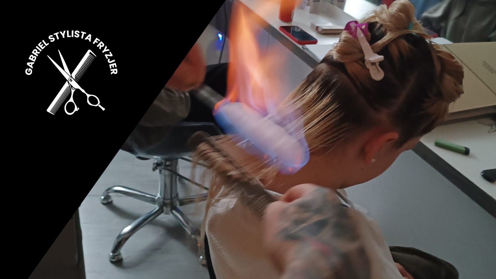 Molekularna odbudowa włosów ogniem: płomień nad grzebieniem podczas zabiegu na blond włosach, widoczne spięte pasma włosów i tatuaż na dłoni.