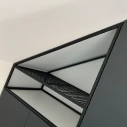 Nowoczesna, grafitowa szafa wnękowa z metalową, ażurową p&oacute;łką pod sufitem, widziana z dołu pod kątem.