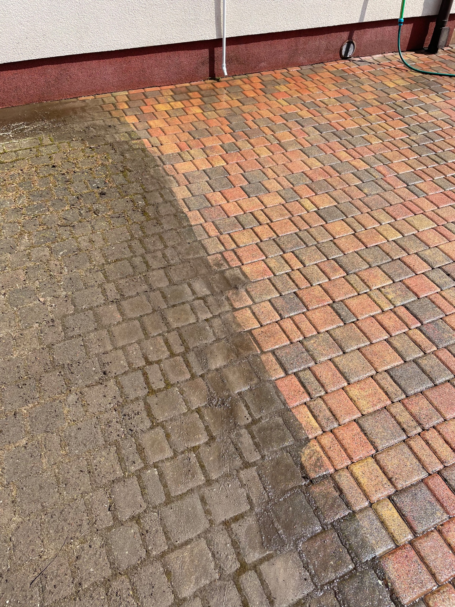 Połowa kostki brukowej wyczyszczona, druga połowa brudna, widoczna różnica w kolorze i czystości.