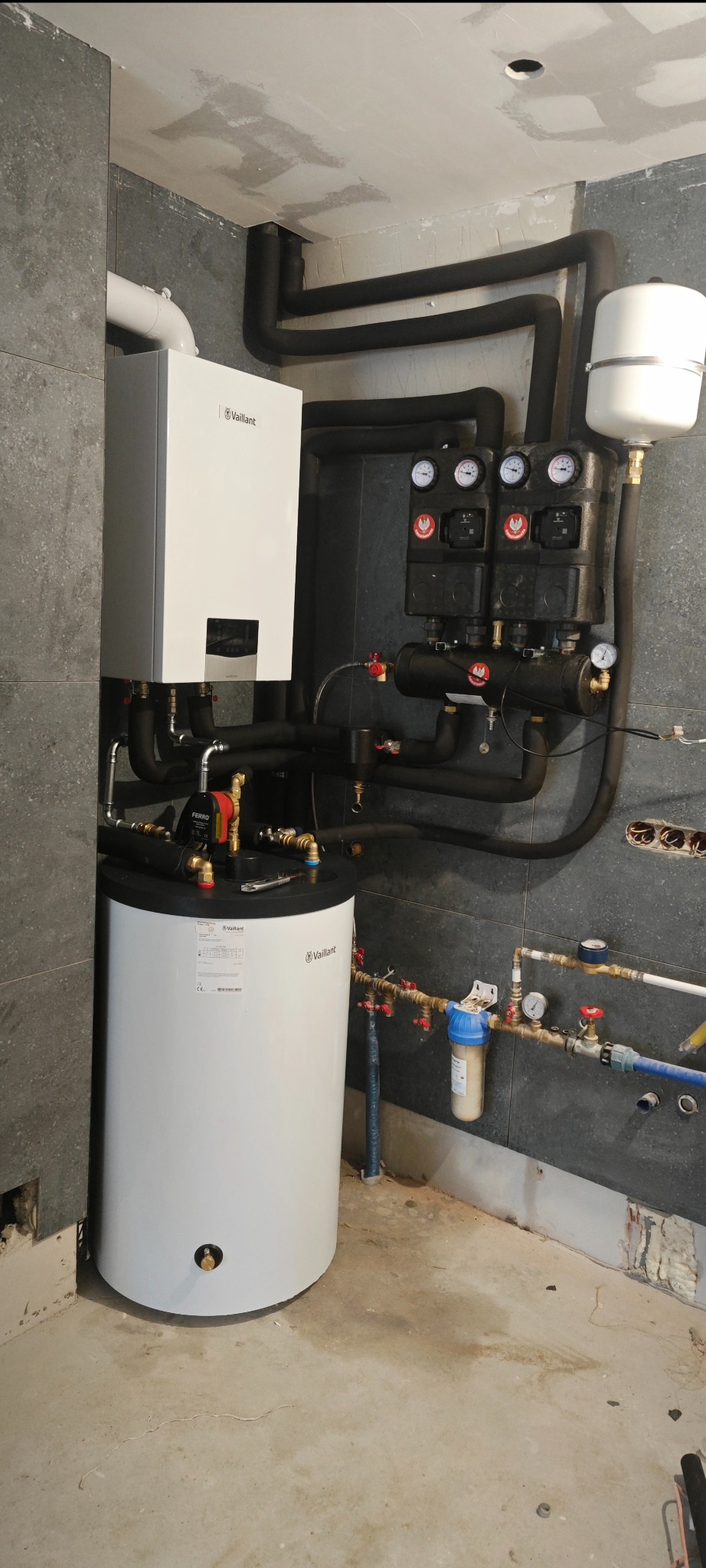 Nowoczesny piec gazowy Vaillant z rozbudowaną instalacją hydrauliczną w kotłowni w Irządzach. Widoczne rury, zawory i czujniki ciśnienia.