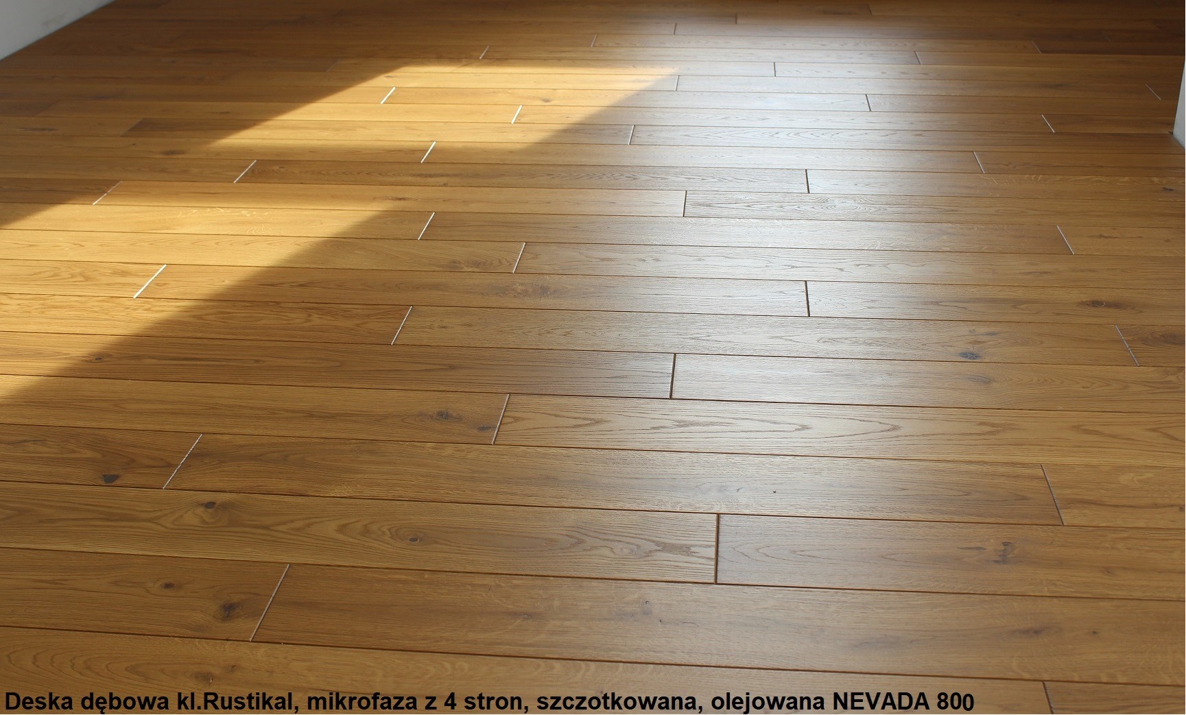 Ułożone deski podłogowe z naturalnego drewna dębowego w odcieniach brązu, wykończone olejem, oświetlone naturalnym światłem słonecznym padającym pod kątem.