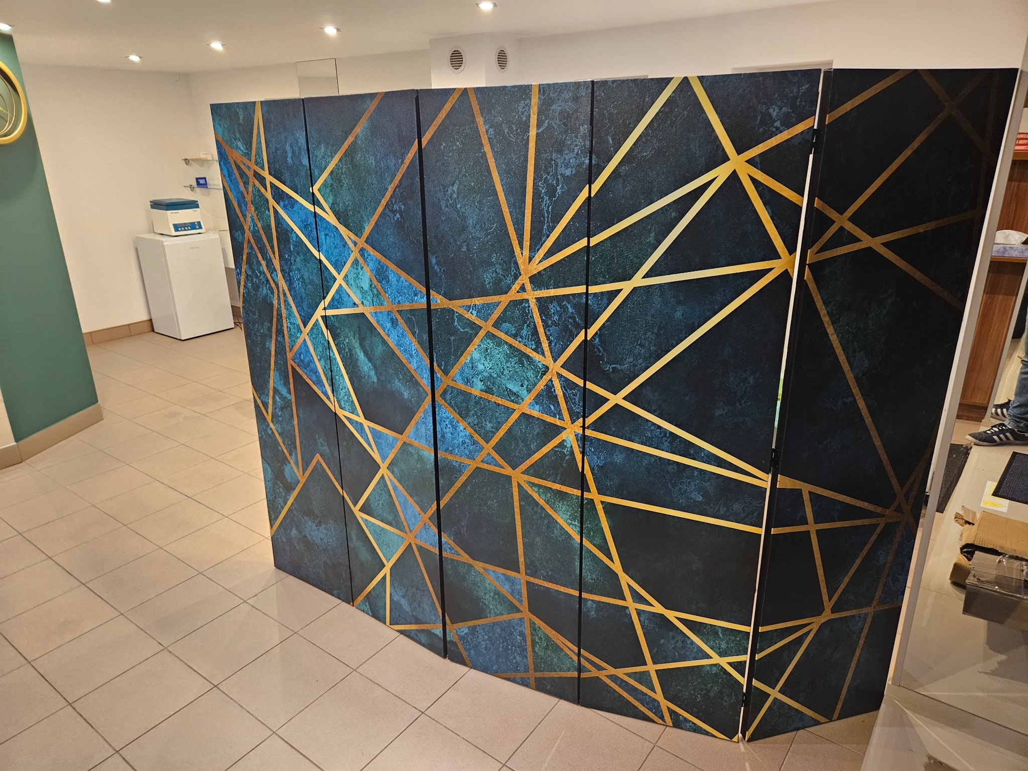 Parawan dekoracyjny z geometrycznym wzorem w gabinecie zabiegowym.