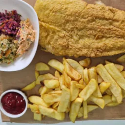 Zestaw obiadowy z rybą w chrupiącej panierce, frytkami i trzema rodzajami surówek podany na brązowym papierze, prawdopodobnie z oferty cateringu świątecznego w Jedlinie-Zdroju. Widoczny również...