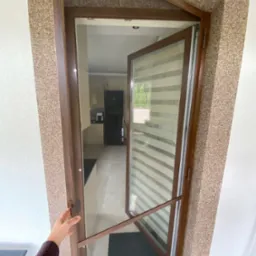 Drzwi moskitierowe z poprzeczką wzmacniającą oraz zawiasami samodomykającymi