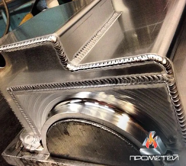 Szczegółowe zbliżenie na spoiny wykonane metodą TIG na aluminiowej konstrukcji, widoczne precyzyjne ściegi i opalizujący metal.