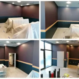 Wnętrze biurowe w trakcie malowania: ściany w dwóch odcieniach fioletu i granatu, zabezpieczone meble pod folią, widoczne taśmy malarskie i metalowy stolik z narzędziami malarskimi.