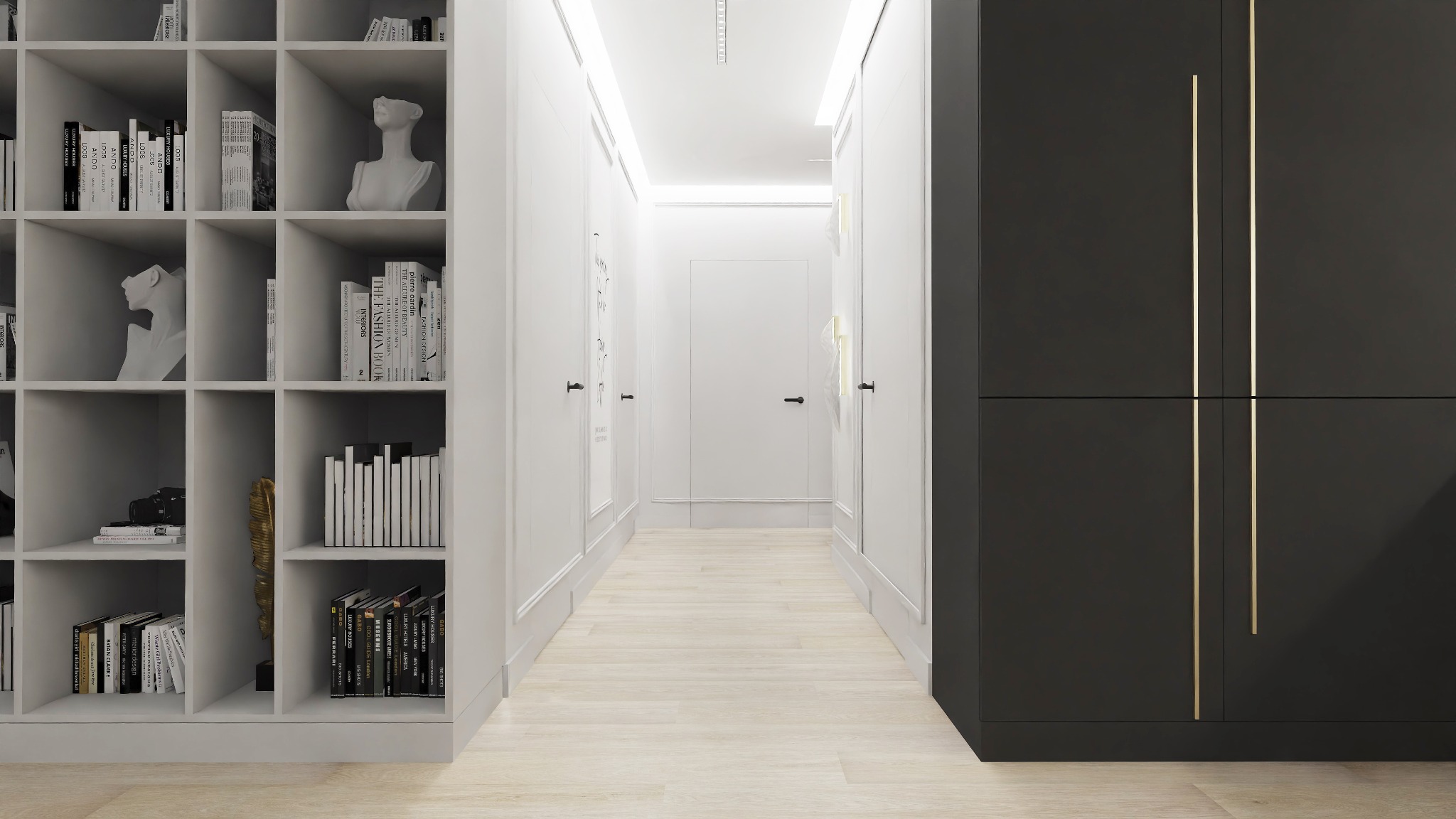 Nowoczesny korytarz z białymi ścianami, jasną podłogą i czarną szafą z wysokimi złotymi uchwytami. Po lewej stronie regał z książkami i rzeźbami.