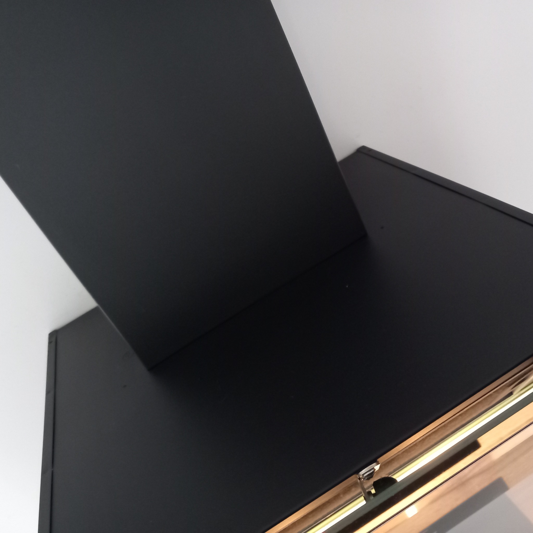 Czarny, nowoczesny okap kuchenny zamontowany pod białym sufitem, widok z dołu.