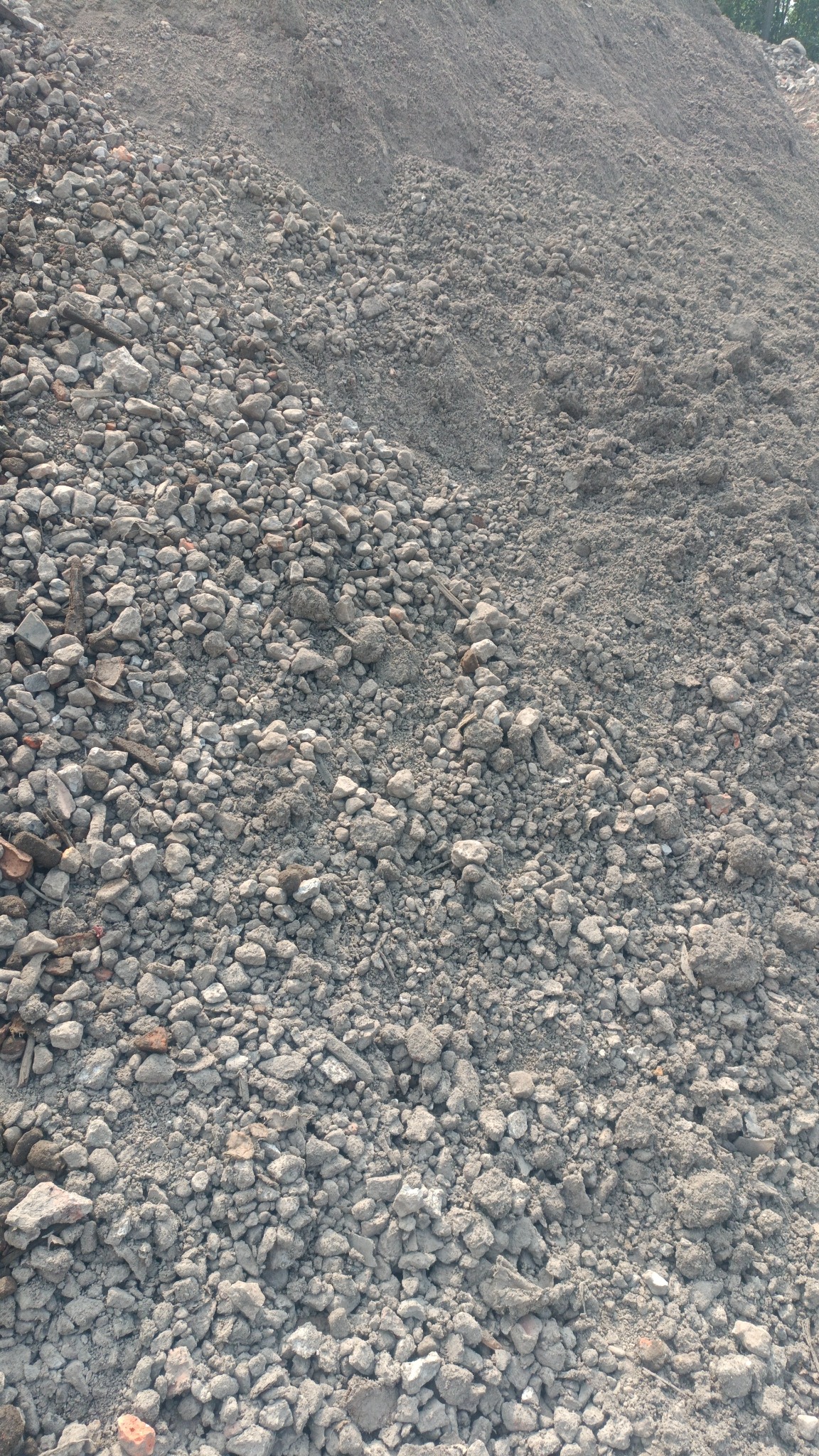 Góra gruzu i ziemi z fragmentami cegieł, pozostałość po pracach budowlanych lub rozbiórkowych.