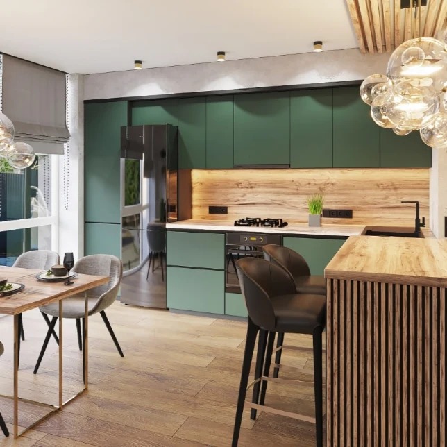 Nowoczesna kuchnia w odcieniach zieleni z drewnianymi akcentami, oświetleniem punktowym i wyspą z hokerami, widok na stół jadalny z nakryciem.
