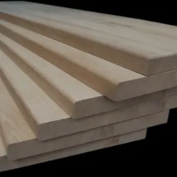 Stos surowych, dębowych stopni schodowych z zaokrąglonymi krawędziami, przygotowanych do montażu, na czarnym tle.