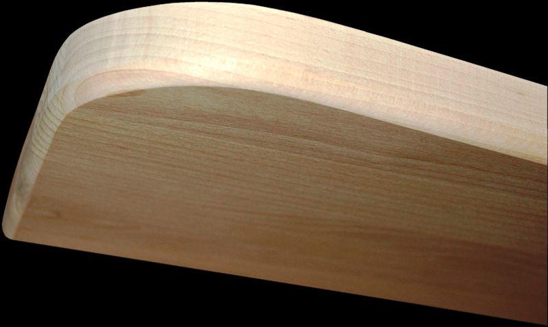 Dwa stopnie schodowe z drewna: jaśniejszy i ciemniejszy, z zaokrąglonymi krawędziami, na czarnym tle.