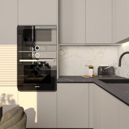 Pracownia Architektury Wnętrz Klaudia Woźniak - Nowoczesna kuchnia w odcieniach szarości z marmurowym backsplashiem, czarną armaturą i sprzętami AGD marki Bosch i Smeg, oświetlona ciepłym światłem słonecznym padającym przez żaluzje.