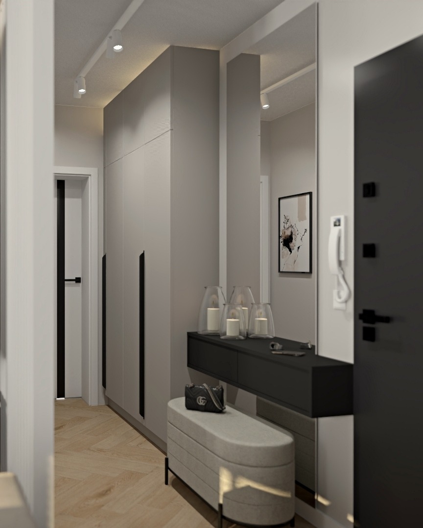 Nowoczesny przedpokój w odcieniach szarości z minimalistyczną szafą, konsolą z dekoracyjnymi lampionami i tapicerowanym siedziskiem z torebką.