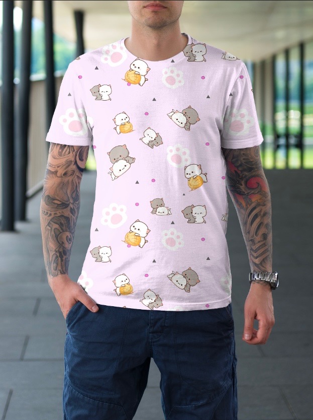 Mężczyzna prezentuje t-shirt z nadrukiem pastelowych kotów, łapek i geometrycznych wzorów na jasnoróżowym tle, widoczne tatuaże na ramieniu i srebrny zegarek na nadgarstku.