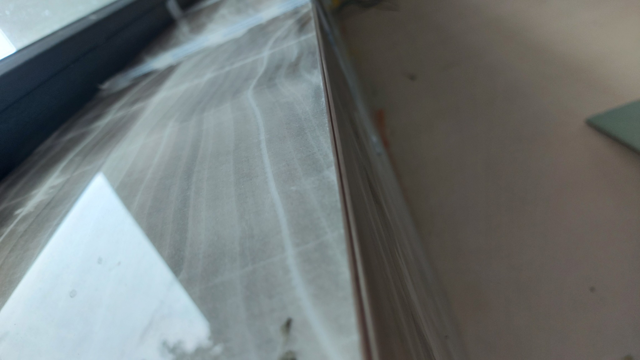 Świeżo położone białe płytki na ścianie, zabezpieczone folią ochronną przed zabrudzeniem podczas dalszych prac wykończeniowych.