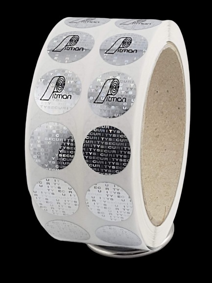 Rolka srebrnych, okrągłych plomb zabezpieczających z logo 'Pitman Security' i mikrodrukiem 'SECURITY', widocznych pod kątem