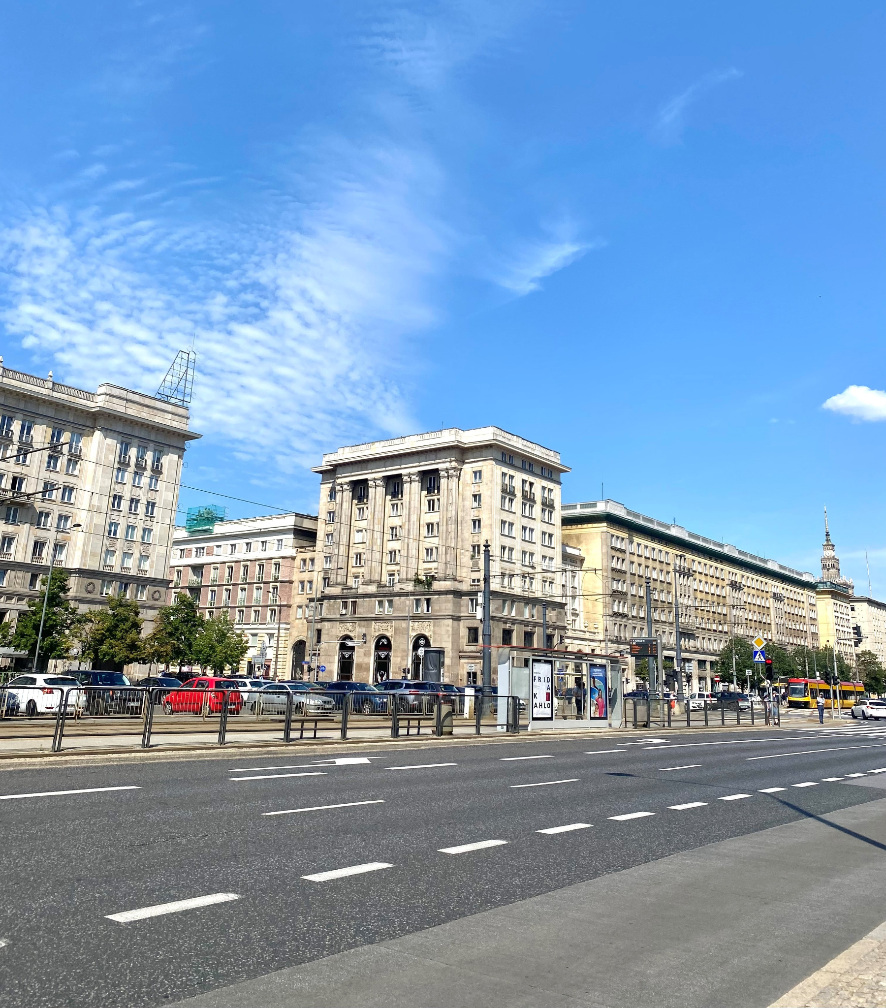 Ulica z perspektywą na monumentalne budynki w stylu socrealistycznym, Warszawa, Polska, błękitne niebo z chmurami cirrus