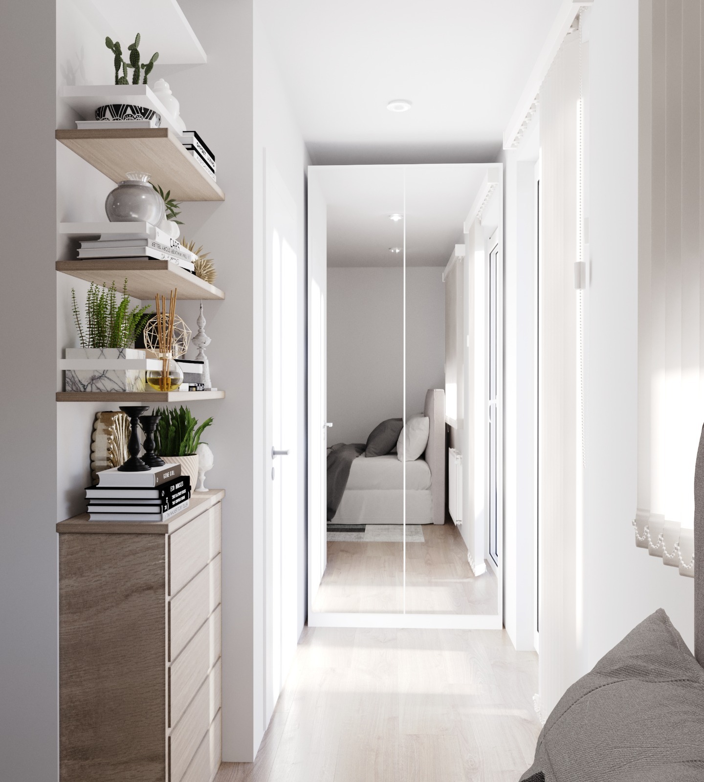 Wnętrze mikrokawalerki w Krakowie z minimalistycznym wystrojem, ukazujące komodę z dekoracjami i lustrzane drzwi do sypialni z łóżkiem.