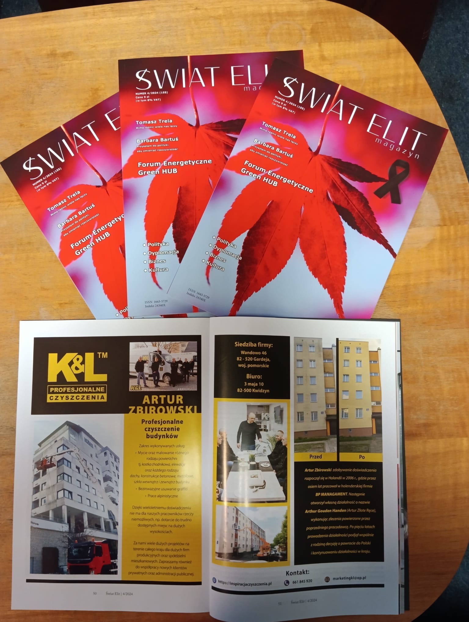 Reklama firmy K&L Artur Zbirowski w magazynie 'Świat Elit' prezentująca profesjonalne czyszczenie budynków, z przykładami realizacji 'przed' i 'po' na tle ułożonych egzemplarzy magazynu z liściem...