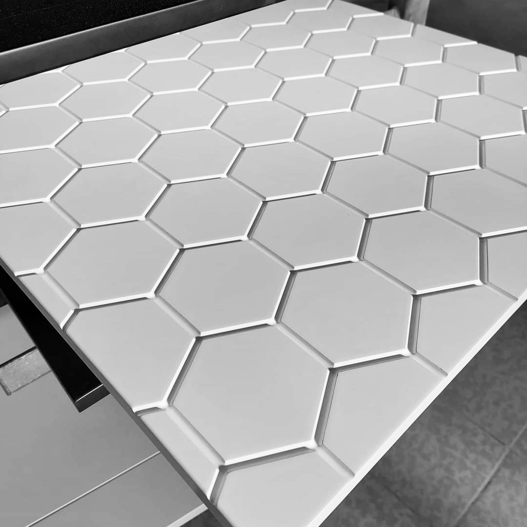 Blat z białych, heksagonalnych płytek, widoczny pod kątem, z delikatnymi fugami i subtelnym oświetleniem.