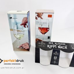 PERFEKTDRUK Joanna Zięba - Zestaw pudełek z nadrukiem przedstawiającym kieliszki do wina z nutami, na białym tle, widoczne logo drukarni.