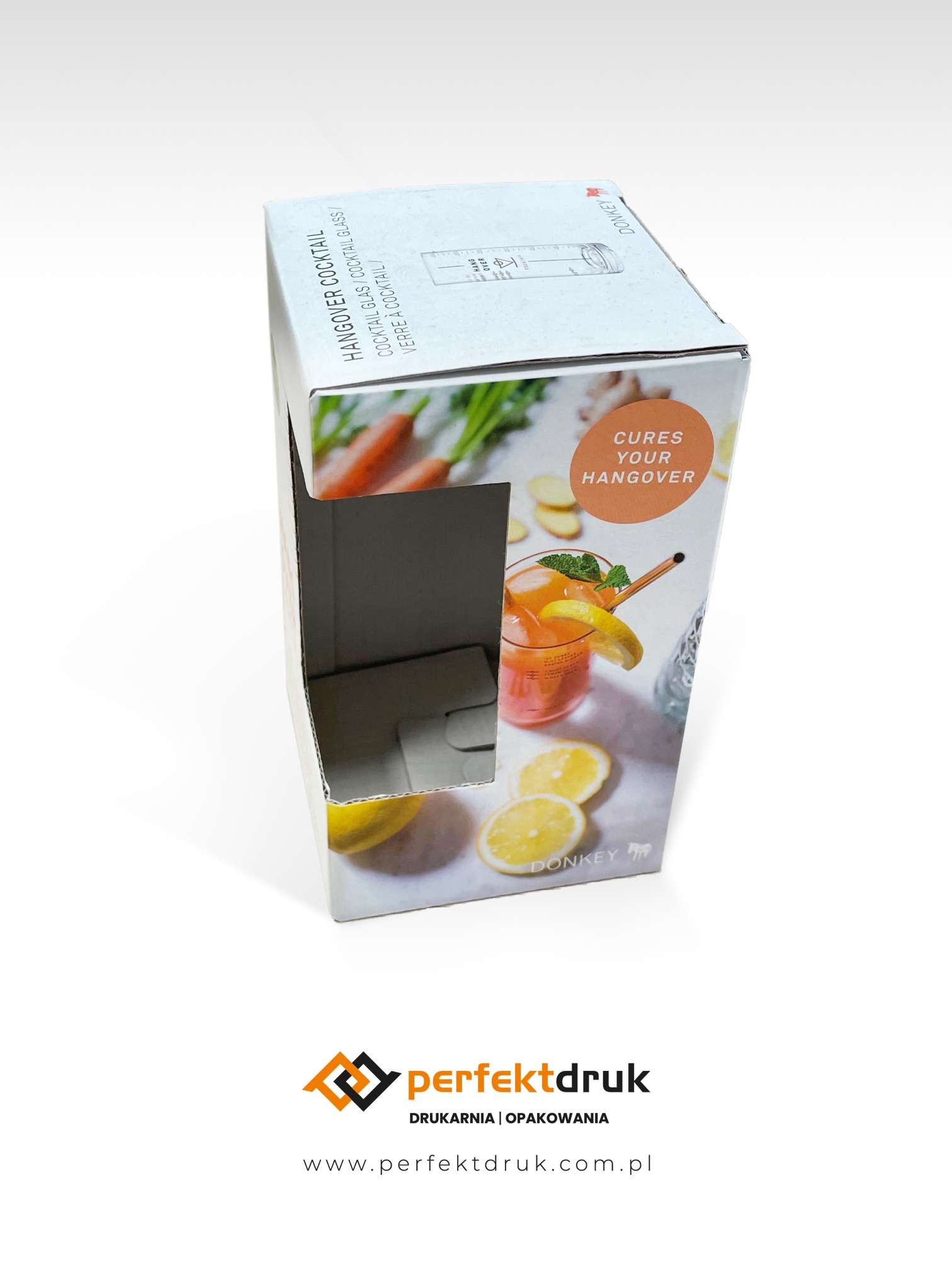 Pudełko z tektury z nadrukiem grafiki przedstawiającej koktajl i hasłem 'Cures Your Hangover', widoczne logo firmy Donkey, na dole logo drukarni Perfektdruk.